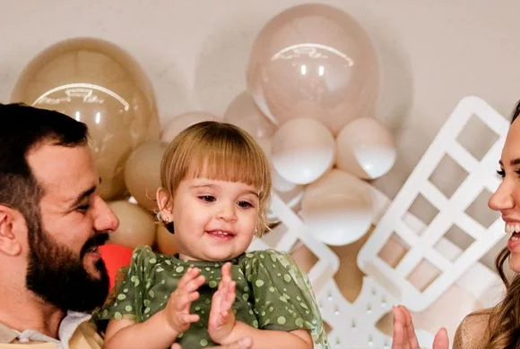 Lívia, o marido e a filha na festa
