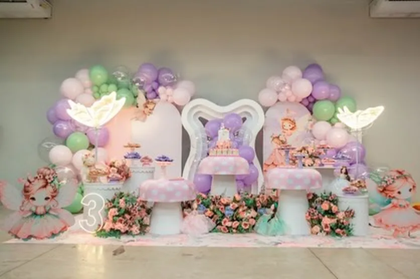 Decoração com tema conto de fadas, com trono e fadas em lilás e verde-água
